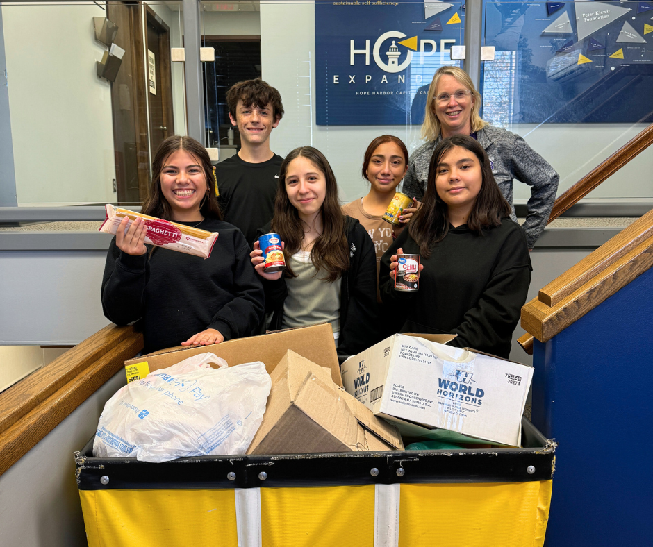 Smiling Barr Middle School NJHS Students with Denise Pedersen at Hope Harbor dropping-off a crate of donated goods.